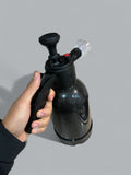 Black hand pump held by a person against a gray background