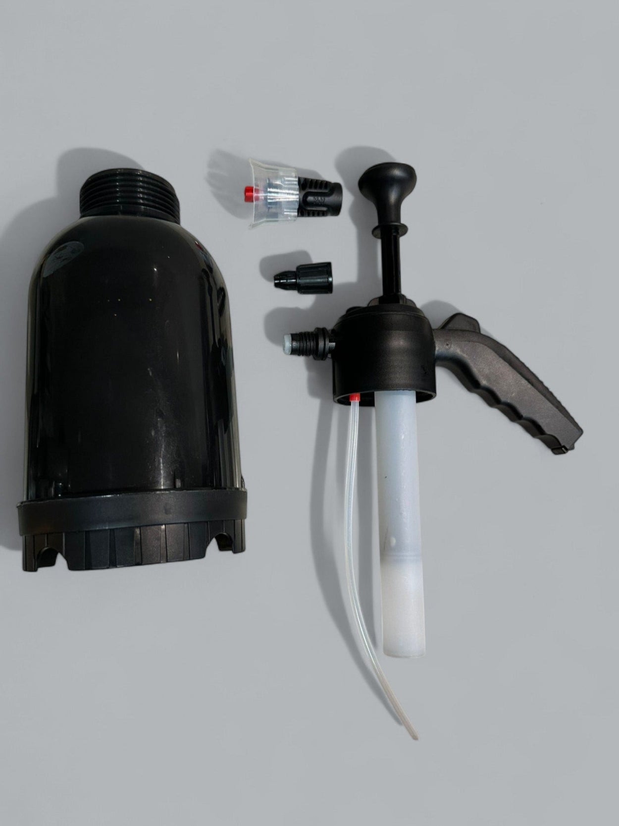 Black pump and spray nozzle set on a gray background